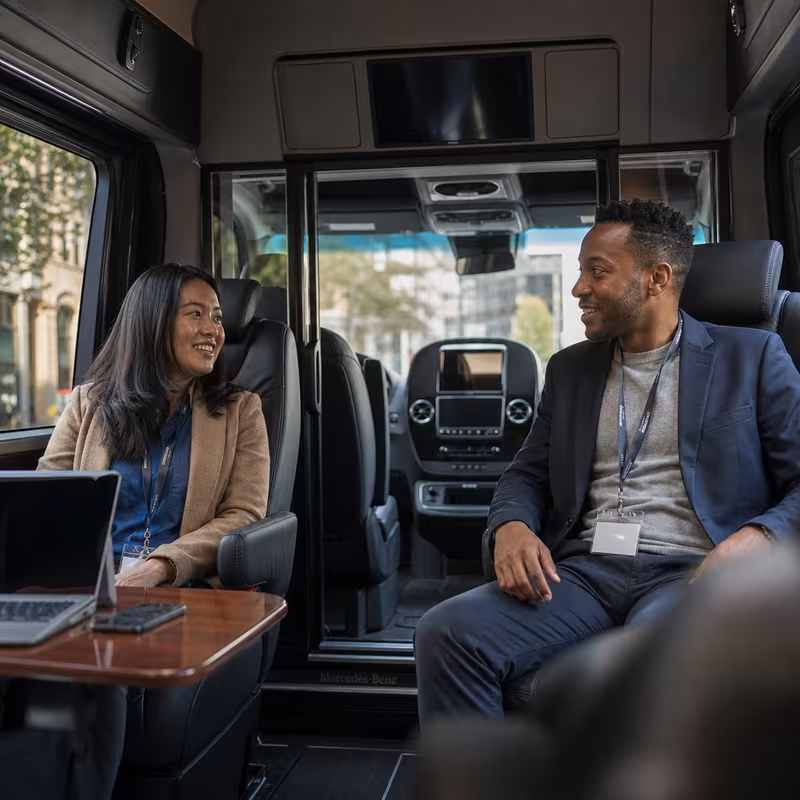 Group boarding a white charter bus for Corporate Transportation transportation in Hayward