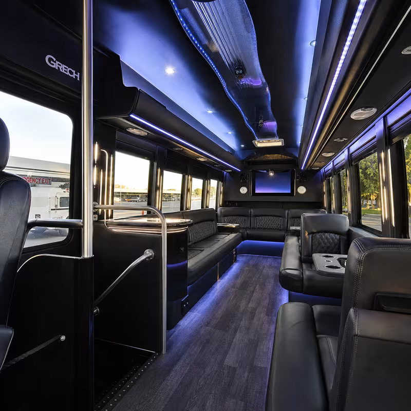 Party bus interior with wraparound leather seating and LED lighting in Hayward