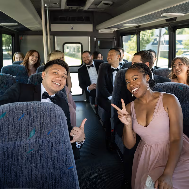 Group boarding a white charter bus for Wedding Transportation transportation in Hayward